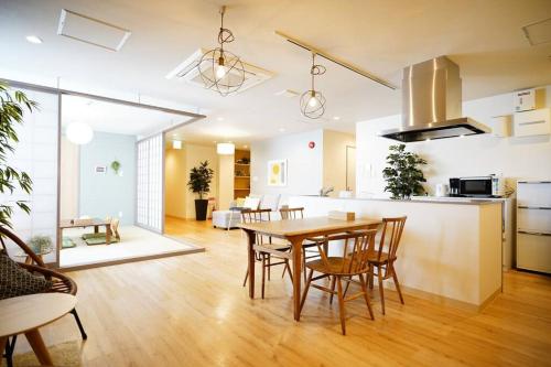 una cucina e un soggiorno con tavolo e sedie in legno di Condominium Riana a Naha