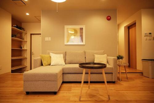 ein Wohnzimmer mit Sofa und Tisch in der Unterkunft Condominium Riana in Naha