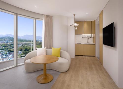 a living room with a white couch and a table at Cassia Sokcho in Sokcho
