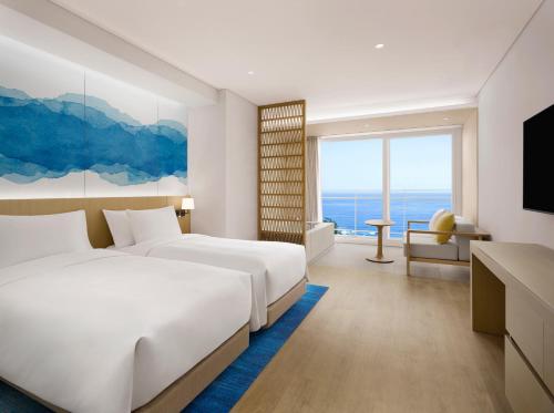 a hotel room with two beds and a television at Cassia Sokcho in Sokcho