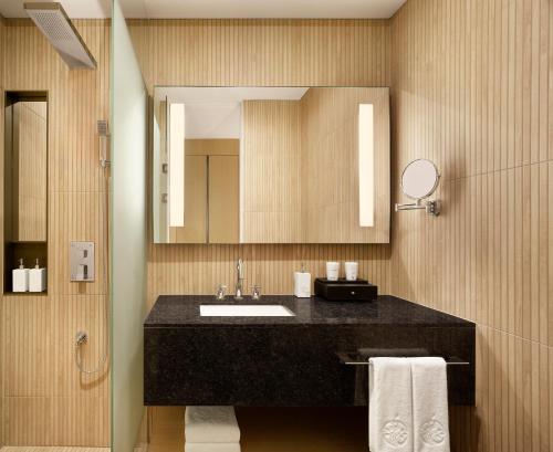 a bathroom with a sink and a mirror at Cassia Sokcho in Sokcho