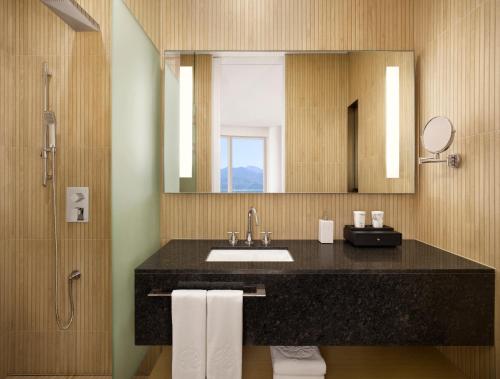 a bathroom with a sink and a mirror at Cassia Sokcho in Sokcho