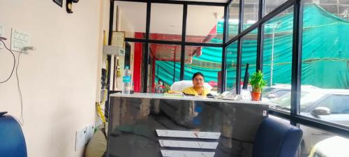 ヴィシャカパトナムにあるHOTELPEACOCKINNの店のカウンターに座る男