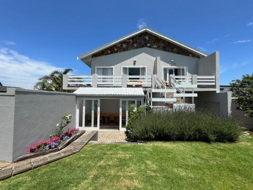a large white house with a yard at Moments Guesthouse, Kleinmond in Kleinmond