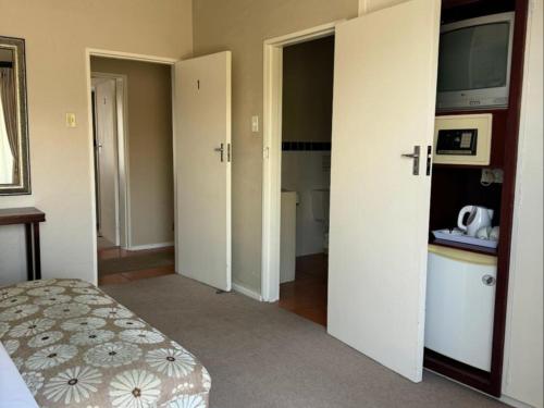 a bedroom with a bed and a bathroom with a sink at Moments Guesthouse, Kleinmond in Kleinmond