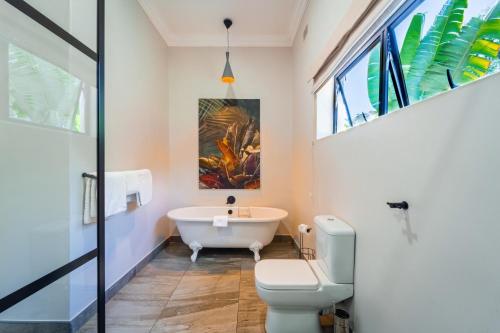a bathroom with a bath tub and a toilet at Nkosi Guest Lodge in Victoria Falls