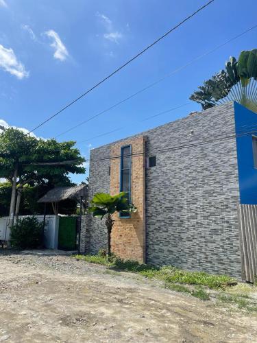 a brick house with a plant on the side at La casa de naty by Ecuapolsky in Tonsupa