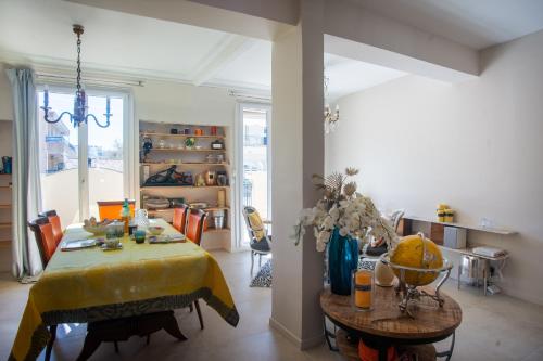 un salon avec une table et un chiffon de table jaune dans l'établissement Authentic Nice Apartment - Sunny Terrace - Happy Rentals, à Nice