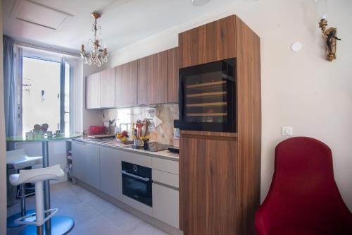 une cuisine avec une chaise rouge à côté d'un comptoir dans l'établissement Authentic Nice Apartment - Sunny Terrace - Happy Rentals, à Nice