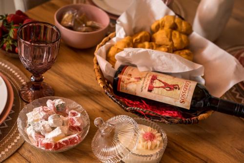 a table with a basket of bread and a bottle of wine at Sea Breeze & Nature villa ,near the sea, luxury jagguzi and spa private garden in Kremasti