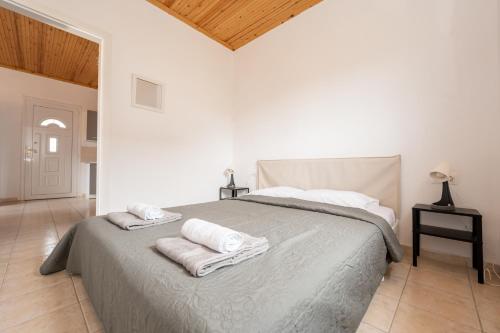 a white bedroom with a bed with towels on it at Flegra House in Nea Potidaea