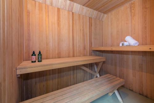 una sauna con dos botellas de alcohol y un banco en MontBlanc Alpine Ski & Sauna Retreat - Happy Rentals, en Le Tour