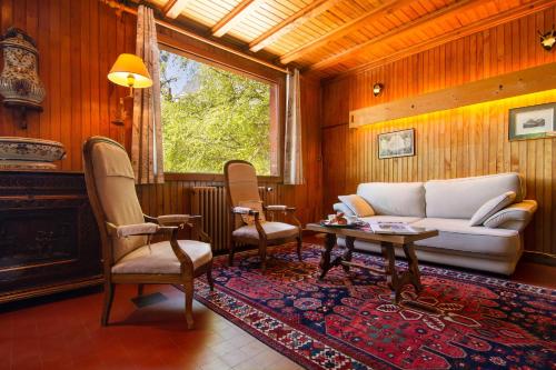 Una sala de estar con un sofá y sillas y una mesa. en MontBlanc Alpine Ski & Sauna Retreat - Happy Rentals, en Le Tour