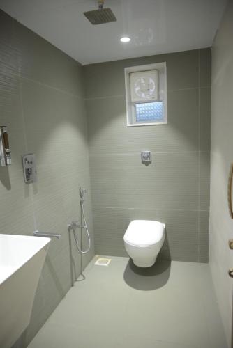 a bathroom with a toilet and a sink and a window at Tattvamasi Retreat in Mumbai