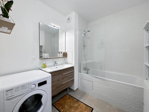 een wasmachine in een badkamer met een douche bij Logement pour 7 Disneyland vue sur feu d artifice in Chessy