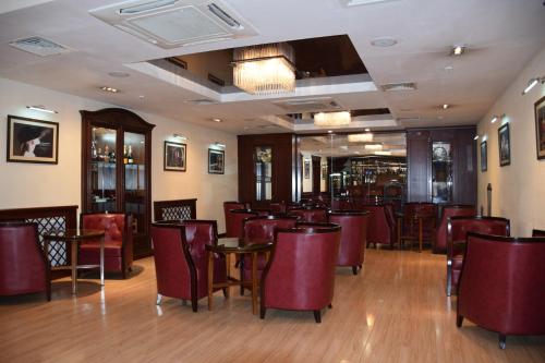 a restaurant with red chairs and tables in a room at Park Hotel Bishkek in Bishkek