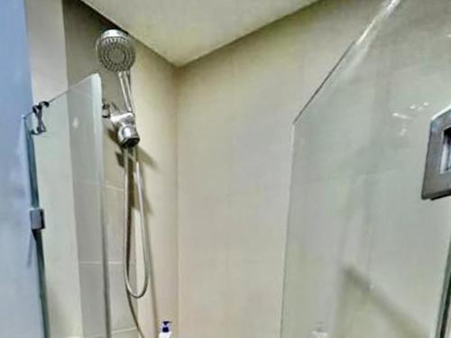 a shower in a bathroom with a shower head at Studio Type Condo City View 23rd F Abreeza Place in Davao City