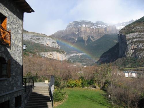 a rainbow in the mountains with a building at Hotel Abetos in Torla