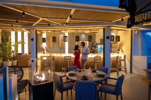 Ein Mann und eine Frau stehen in einem Restaurant in der Unterkunft Petit Palace Suites in Fira