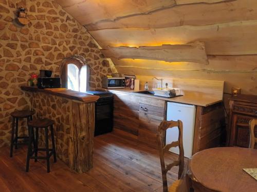- une cuisine dans une cabane en rondins avec une table et des chaises dans l'établissement Hobbit Mont Saint Michel Castel Brandy, à Tanis