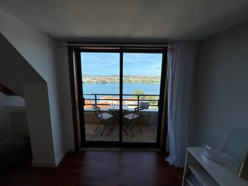 a room with a balcony with a view of the ocean at O Faiado Da Ria By Oktheway in Culleredo
