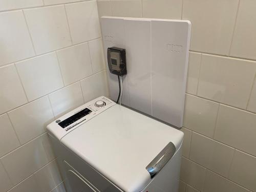a white machine in a bathroom with a phone at Apartmány Vodohospodár in Mýto pod Ďumbierom