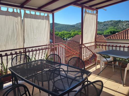 a patio with a table and chairs on a balcony at Guest Accomodation Žura in Skradin