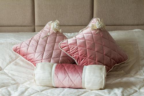 a pair of pink pillows sitting on a bed at Park Hotel Bishkek in Bishkek