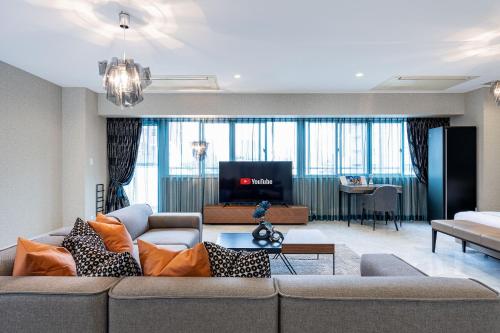 a living room with a couch and a tv at JAPAVISTA Xenith Premium in Osaka