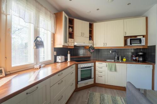 a kitchen with wooden counters and white cabinets at Aidattu omakotitalo - Palju lisämaksusta in Kalajoki