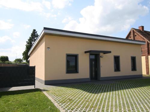 a small white house with a driveway at Ferienhaus am Rande der Lewitz in Lüblow