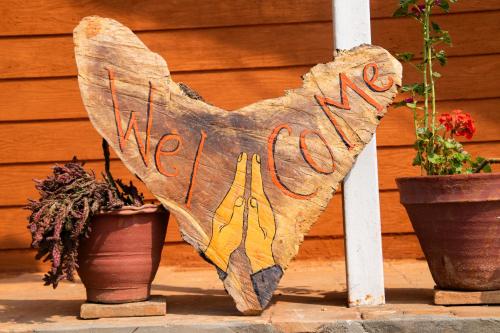 a wooden heart sign sitting next to two pots at Les Terrasses Himalayan Resort in Charikot