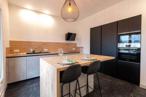 une cuisine avec un îlot en bois avec deux chaises de bar dans l'établissement Belle maison rénovée avec jacuzzi, à Saint-Rémy