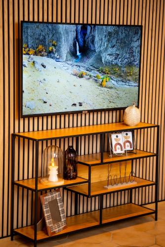 a television hanging on a wall with a shelf at Boutique Apartment Niederrhein in Friedrichsfeld