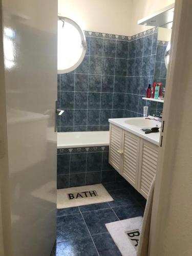 une salle de bain avec une baignoire, un lavabo et un tapis de bain dans l'établissement Marina Port Lairan à port Camargue, au Grau-du-Roi