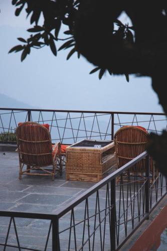 two chairs and a table with a basket on a fence at Les Terrasses Himalayan Resort in Charikot