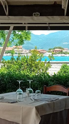 a table with glasses and a view of the ocean at Hotel Garden Bocca di Magra in Bocca di Magra