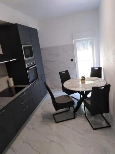 a kitchen with a table and chairs in a room at Apartment Anđela in Podgora