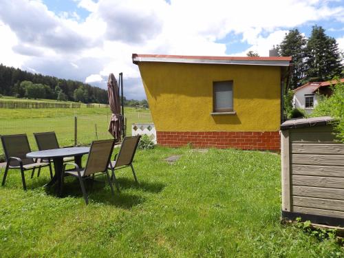a table and chairs in the grass next to a building at Haus am Candelaber in Altenbergen