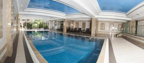 a large swimming pool in a building with a ceiling at Park Hotel Bishkek in Bishkek