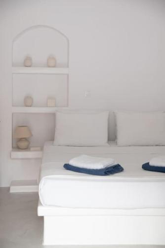 a white bedroom with two beds and white shelves at Thavma Milos in Firopótamos