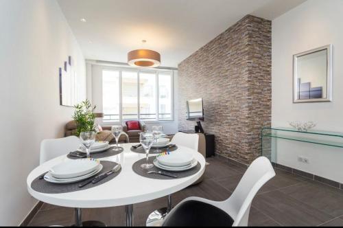 une salle à manger avec une table et des chaises blanches dans l'établissement Royal apartment near the beaches, à Nice