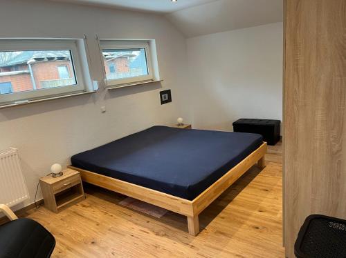 ein Schlafzimmer mit einem Bett in einem Zimmer mit zwei Fenstern in der Unterkunft Haus Sonnenschein in Wunstorf