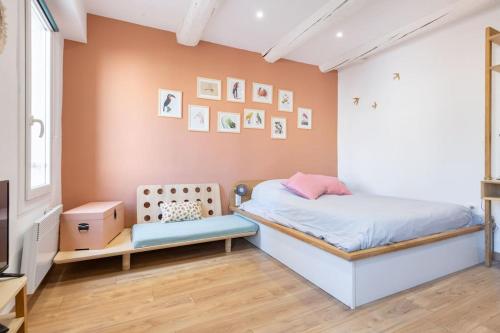 - une chambre avec un lit et un mur avec des photos dans l'établissement Le Cocon de Grignan, à Marseille