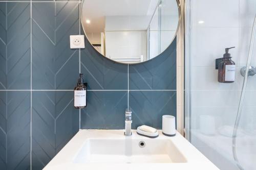 une salle de bains avec un lavabo et un miroir dans l'établissement Le Cocon de Grignan, à Marseille