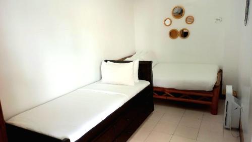 two beds in a small room with white walls at The Philip Ann Resort in Mabini