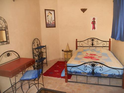a bedroom with a bed and a table and chairs at We are looking forward to welcoming you to our home in Essaouira