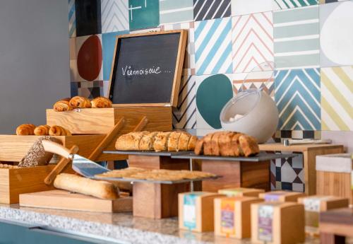 a bakery counter with bread and pastries on display at B&B HOME Paris Mairie de Saint-Ouen in Saint-Ouen