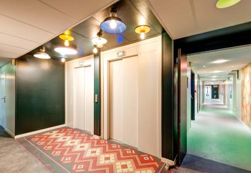 a hallway with a corridor with a door and a carpet at B&B HOME Paris Mairie de Saint-Ouen in Saint-Ouen
