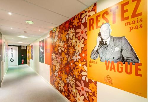 a hallway with a painting of a man on a wall at B&B HOME Paris Mairie de Saint-Ouen in Saint-Ouen